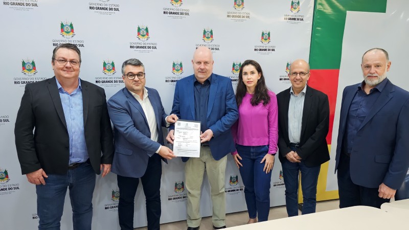 Secretario adjunto Marcelo Camardelli e o presidente da Fepam, Renato Chagas em pé entregando a licença de instalação