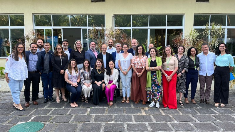 Participantes em foto posada, dispostos em formato de "U", em local aberto.