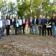 Representantes do Governo RS e representantes da Mahindra posam com a licença na área que receberá o empreendimento