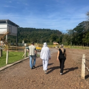 Três pessoas caminham a céu aberto, em vistoria da Fepam