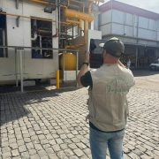 Homem tira foto de construção em complexo industrial durante vistoria da Fepam
